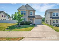 Charming two-story home boasts a well-manicured lawn, inviting curb appeal, and attached garage at 3578 Saddlebrook Dr, Midland, NC 28107