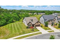 Stunning aerial shot of a home with a well-manicured lawn and lush green neighborhood, in a friendly community at 475 Hunton Forest Nw Dr, Concord, NC 28027