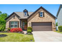 Charming brick home featuring a two-car garage and inviting front yard with colorful landscaping at 475 Hunton Forest Nw Dr, Concord, NC 28027