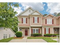 Charming tan two-story townhouse featuring red shutters, landscaped yard, and well-maintained lawn at 8259 Carob Tree Ln, Charlotte, NC 28215