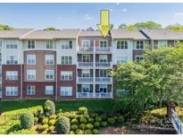Apartment building with brick and siding, featuring multiple balconies on a sunny day at 1000 E Woodlawn Rd # 408, Charlotte, NC 28209