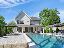 Stunning backyard featuring a sparkling pool, lounge chairs, and a covered patio perfect for outdoor entertaining at 1009 Belmont Ave, Charlotte, NC 28205