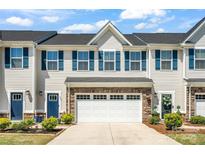 Charming townhome with a two-car garage, blue shutters, and a beautifully landscaped front yard at 10436 Dalton Woods Nw Ct, Huntersville, NC 28078