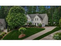 Well maintained two-story home with beautiful landscaping and a long driveway leading to an attached garage at 109 Braxton Gate Ct, Mount Holly, NC 28120