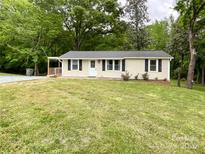 Charming single-story home featuring a well-manicured front yard with green grass and a small porch at 1105 S Church S St, Monroe, NC 28112
