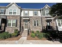 Charming townhome showcasing a stone facade, well-manicured landscaping, and inviting entryway with steps at 11741 Blessington Rd, Huntersville, NC 28078