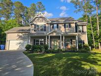 Charming two-story home with a landscaped front yard, a welcoming porch, and an attached two-car garage at 1200 Kent Dr, Lancaster, SC 29720