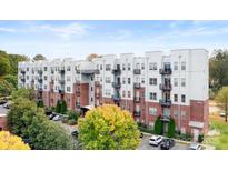 Modern apartment building with brick and white siding, balconies, and landscaped grounds at 2338 Yadkin Ave # 101, Charlotte, NC 28205