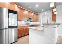 Modern kitchen with granite countertops, stainless steel appliances, and wooden cabinets at 2338 Yadkin Ave # 101, Charlotte, NC 28205