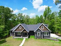 Charming single-Gathering home featuring a well-manicured lawn, gray siding and a walkway leading to the front entrance at 2694 Woodcrest Sw Dr, Concord, NC 28027