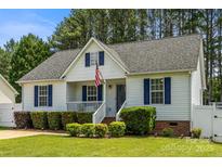Charming single-Gathering home featuring a well-kept lawn, blue shutters, and a welcoming front porch with an American flag at 311 Masters Dr, Rock Hill, SC 29732