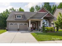 Charming home featuring a two-car garage, covered porch and a beautifully landscaped front yard at 3186 Helmsley Ct, Concord, NC 28027