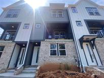 Modern townhome showcasing a light brick facade, two-tone siding, and a covered balcony in a vibrant community at 412 Nathaniel Way # Brx0052, Charlotte, NC 28213