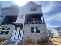 Modern townhome with brick and siding, featuring a welcoming entrance and a balcony, perfect for outdoor living at 416 Nathaniel Way # Brx0051, Charlotte, NC 28213