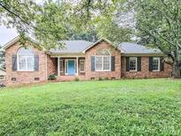 Charming brick home with arched windows and a well-maintained lawn at 6231 Kentwood Dr, Kannapolis, NC 28081