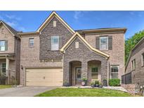 Charming two-story brick home with a stone facade, attached garage, and well-manicured lawn at 6618 Vizcaya Ct, Charlotte, NC 28226
