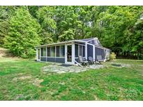 Charming sunroom featuring screened windows, stone patio, and outdoor seating, perfect for relaxing in nature at 715 Potneck Rd, Salisbury, NC 28147