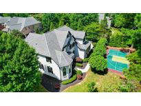 Stunning aerial view of a home featuring a grey roof and a backyard basketball court at 8707 Fairview Rd, Charlotte, NC 28226