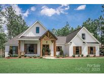Stunning two-story farmhouse with white siding, wooden accents, and a well-manicured lawn at 0 Ellis Spring Ct, Albemarle, NC 28001