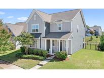 Charming two-story home with gray siding, manicured landscaping, and a welcoming front porch at 13359 Caite Ridge Rd, Davidson, NC 28036