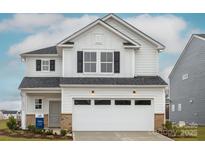 Charming two-story home featuring white siding, black shutters, and an attached two-car garage at 14015 Penbury Ln # 373, Charlotte, NC 28278