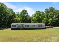 Charming single-story home on a lush green lawn with mature trees in the background at 145 Mccreek Dr, China Grove, NC 28023