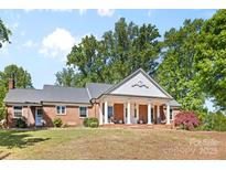 Sprawling single-story brick home showcasing elegant columns and a covered front porch at 1574 Jarrett Farm Rd, Newton, NC 28658