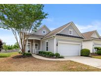 Charming gray home featuring a well-manicured front yard and attached two-car garage at 16291 Raven Crest Dr, Indian Land, SC 29707