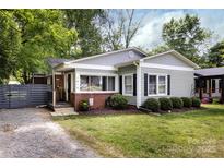 Charming home featuring gray siding, brick accents, well-manicured lawn, and cozy front porch at 1816 Anderson St, Charlotte, NC 28205
