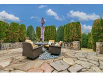 Inviting back patio with stone pavers, stylish seating and lush landscaping provides a private outdoor space at 2106 Yellowstone Dr, Fort Mill, SC 29707