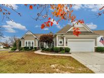 Charming single-story home with manicured landscaping, attached garage, and inviting curb appeal on a sunny day at 2106 Yellowstone Dr, Fort Mill, SC 29707