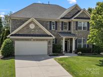 Beautiful two-story brick home with a well-manicured lawn and a two-car garage and black shutters at 2467 Chatham Dr, Fort Mill, SC 29707