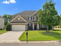 Charming two-story brick home with a well-manicured lawn and attached two-car garage at 2467 Chatham Dr, Fort Mill, SC 29707