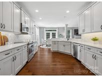 Bright kitchen featuring stainless steel appliances, white cabinetry, and hardwood floors at 2467 Chatham Dr, Fort Mill, SC 29707