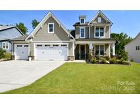 Charming two-story home with a well-manicured lawn, attached two car garage and inviting front porch at 262 Country Lake Dr, Mooresville, NC 28115