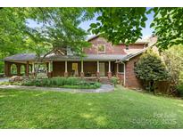 Charming brick home with covered porch and manicured front lawn creating an inviting curb appeal at 332 York Spann Rd, Hamptonville, NC 27020