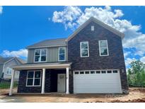 Charming two-story home featuring a stone facade, attached two car garage and well manicured lawn at 3888 12Th Ne St, Hickory, NC 28601
