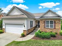 Charming single-Gathering home with manicured lawn, two-car garage, stone accents, and neutral color palette at 54053 Flycatchers Ct, Fort Mill, SC 29707