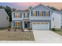 Charming two-story home featuring a two car garage, welcoming entrance and manicured landscaping at 725 Pointe Andrews Dr, Concord, NC 28025