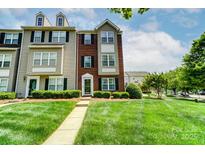 Charming brick and siding townhome with well-manicured lawn and inviting entrance at 9204 Washam Potts Rd, Cornelius, NC 28031