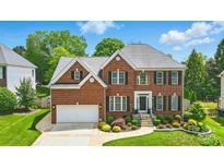 Charming brick home featuring manicured landscaping, a two-car garage, and classic architectural details at 10223 Willingham Rd, Huntersville, NC 28078