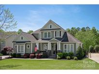 Charming home with manicured lawn, covered front porch, and American flag in a lovely, residential neighborhood at 1148 Wessington Manor Ln, Fort Mill, SC 29715