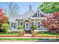 Charming historic home featuring a well-maintained lawn and garden and a welcoming front porch at 116 N Mulberry St, Statesville, NC 28677