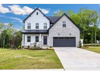 Charming two-story home featuring a stone and siding facade, black accents, and a well-manicured lawn at 1500 Nectar Way # 32, Kannapolis, NC 28083
