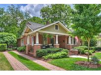 Charming brick home with a landscaped yard and inviting front porch at 1804 Thomas Ave, Charlotte, NC 28205