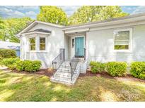 Charming, white-painted brick home featuring a bright blue front door and well-maintained landscaping at 22330 Torrence Chapel Rd, Cornelius, NC 28031