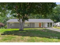 Charming single-story home with a covered carport, gray brick facade, and a large shade tree in the front yard at 2322 Hedgewood Cir, Gastonia, NC 28052