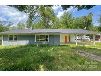 Charming single story home with a brick exterior, large covered parking area and a large front yard at 2322 Hedgewood Cir, Gastonia, NC 28052