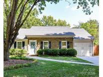 Charming brick home with a well-manicured lawn and inviting walkway leading to the front door at 2401 Birnen Dr, Charlotte, NC 28210