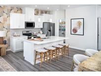 Modern kitchen boasts white cabinets, stainless steel appliances, and a spacious island with seating at 2460 Hedgecliff Rd, Kannapolis, NC 28025